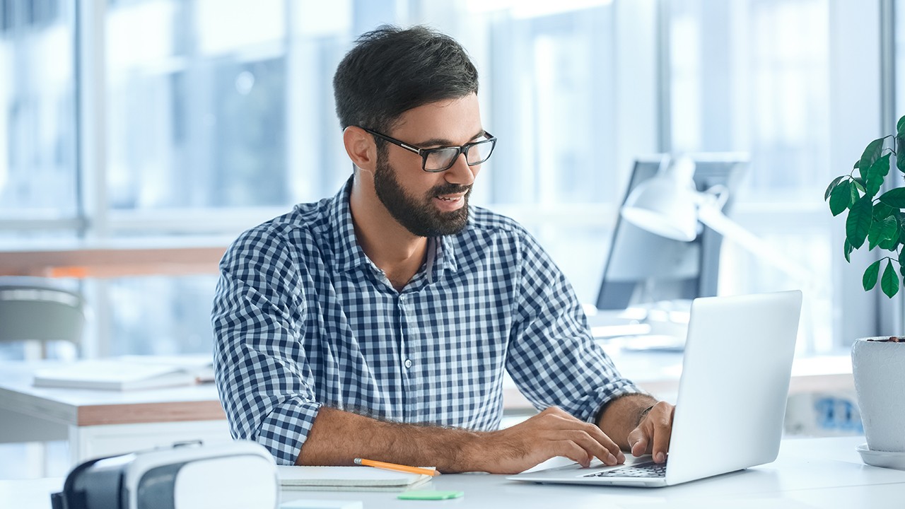 Employee working on laptop in nice office